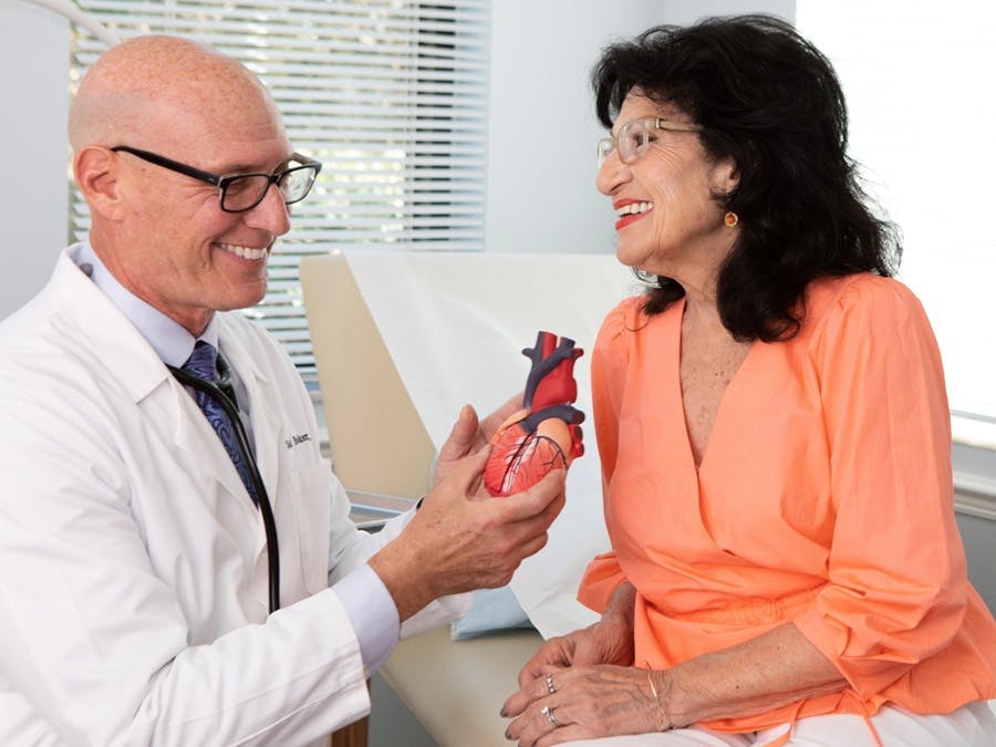 Dr. Baker showing patient a model heart